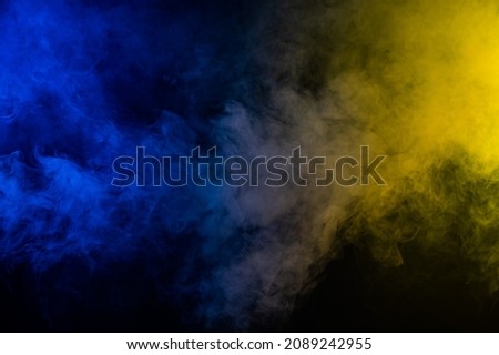 Yellow-blue smoke in neon light on black background. Royalty-Free Stock Photo #2089242955