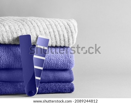 Stack of sweaters and color fun palette in violet color of 2020 year very peri. Demonstrating color of 2022 year very peri for fashion and clothing industry. Copy space Royalty-Free Stock Photo #2089244812
