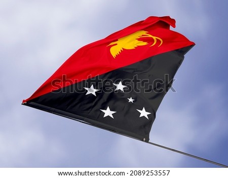Papua New Guinea's flag is isolated on a sky background. flag symbols of Papua New Guinea. close up of a Papua New Guinean flag waving in the wind.