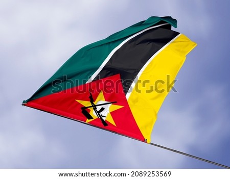 Mozambique's flag is isolated on a sky background. flag symbols of Mozambique. close up of a Mozambican flag waving in the wind.