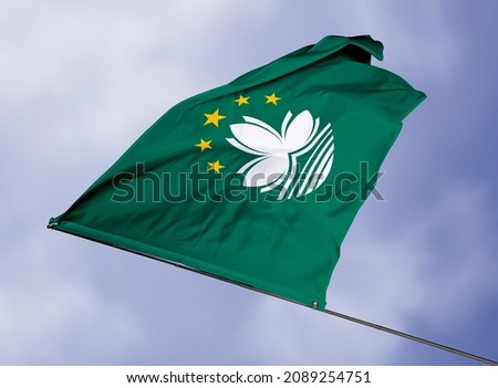 Macau's flag is isolated on a sky background. flag symbols of Macau. close up of a Macanese flag waving in the wind.