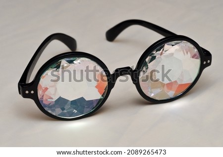 designer glasses with kaleidoscope lenses in black frames on a light background