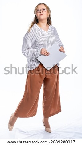 girl studio. model posing at the camera with a book. isolated white background. girl in trousers and blouse, shoes