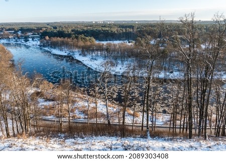 a high angle view from a Verkiai park down to Neris river with flowing ice on a sunny winter day