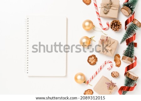 Minimal creative flat lay of winter christmas traditional composition and new year holiday season. Top view open mockup black notebook for text on white background. Mock up and copy space photography.