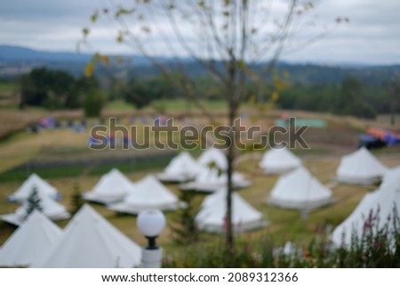Blur focus of tourist tent in the mountains under sunset . Camping.