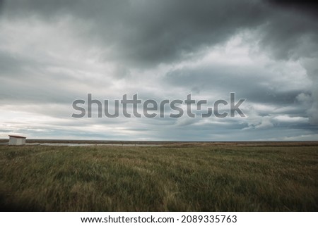 Beautiful icelandic landscape with dried grasses of fall and harsh stormy moody sky Royalty-Free Stock Photo #2089335763
