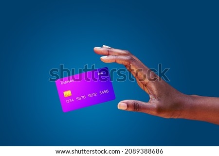 Close up african american female hand and levitating mockup bank credit card with online service on blue background Royalty-Free Stock Photo #2089388686