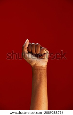 African american clenched fist raised up on red background. Black lives matter. Human rights fight, anti racism protest Royalty-Free Stock Photo #2089388716