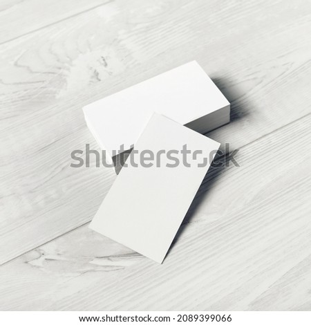 Blank white business cards on light wooden background. Mockup for ID. Template for graphic designers portfolios.