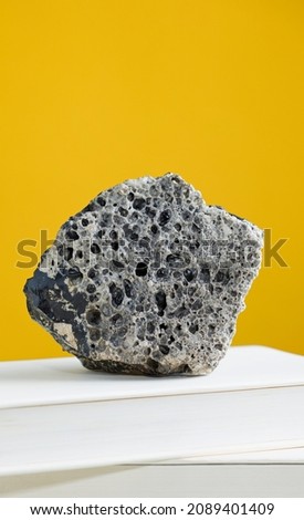 Meteorite rock on textbook, with light brown background.