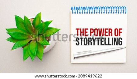 THE POWER OF STORYTELLING is written in a white notepad near a clipboard, calculator, green plant, glasses and a pen on a yellow and concrete backgroundd. Business concept. Flat lay.
