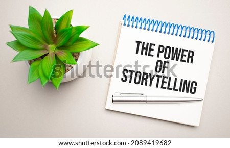 THE POWER OF STORYTELLING is written in a white notepad near a clipboard, calculator, green plant, glasses and a pen on a yellow and concrete backgroundd. Business concept. Flat lay.