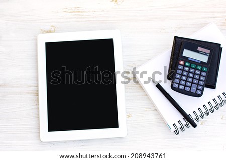 tablet computer, diary, calculator, wallet, pen on the table