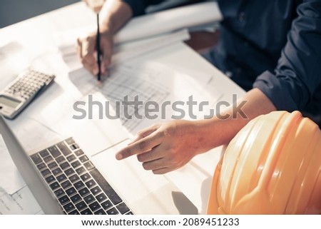 Architect working on blueprint with copy space. Architects workplace - architectural project, blueprints, ruler, calculator. Construction concept. Blue print is fake only for stock photo.