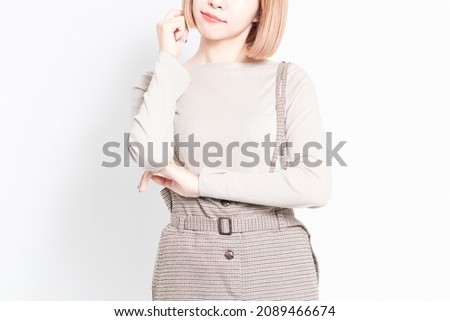 Young girl standing on a white background and thinking