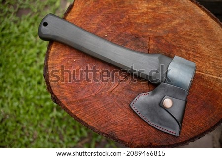 camping axe with leather sheath on log Royalty-Free Stock Photo #2089466815
