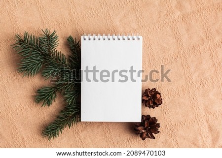 Christmas trendy composition with blank open notebook, fir branches, dried orange on white background. To do list, frame, winter, new year goals concept. Flat lay, copy space, top view, place for text