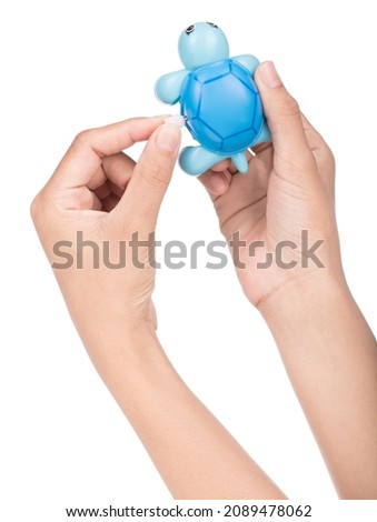 Hand holding Toy Turtle Wind Up Isolated on a white background.