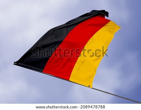 Germany's flag is isolated on a sky background. flag symbols of Germany. close up of a German flag waving in the wind.