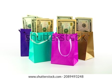 colorful shopping bags filled with US dollar banknotes isolated on white background, business concept