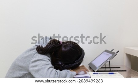 Tired student sleeping in the online home class while studying at home.