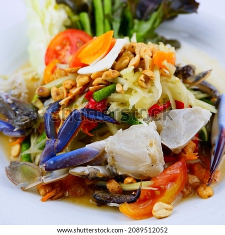 Spicy seafood salad with shrimp, squid, fresh blue crab, popular Thai food, super spicy, put in a blue p