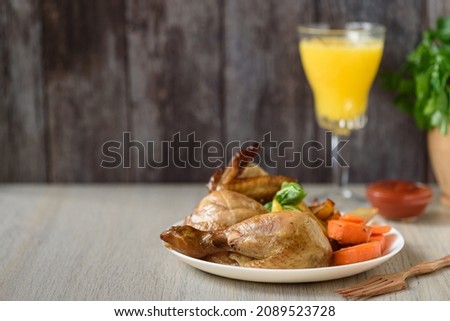 Whole roasted chicken with vegetables. Close up, side view. Copy space.