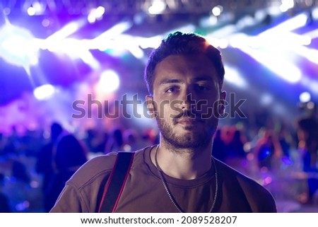 A handsome man in concert . People in the crowd at a concert make video recordings and pics on a smartphone of published in social media.