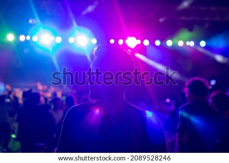 A handsome man in concert . People in the crowd at a concert make video recordings and pics on a smartphone of published in social media
