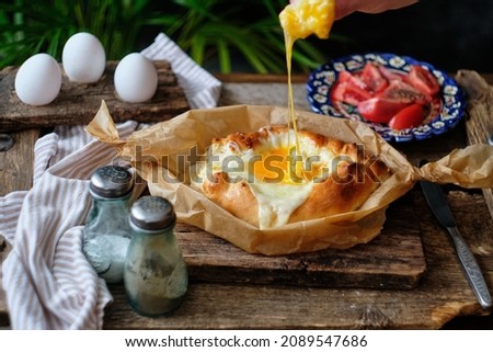 Adjaruli (Acharuli) Khachapuri, Georgian cheese bread. Traditional Georgian recipe made with a bread dough, filled with cheese and crowned with an egg and a butter.  Royalty-Free Stock Photo #2089547686