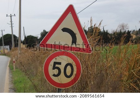 A traffic sign. Grass electricity and trees in picture. Photo taken on the road in burhaniye town Aegean sea coast region turkey anatolia asia. Calm warm weather day in winter