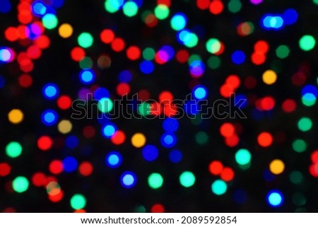 Blurred lights from the Christmas tree, abstract light bokeh, nightlife background.                               