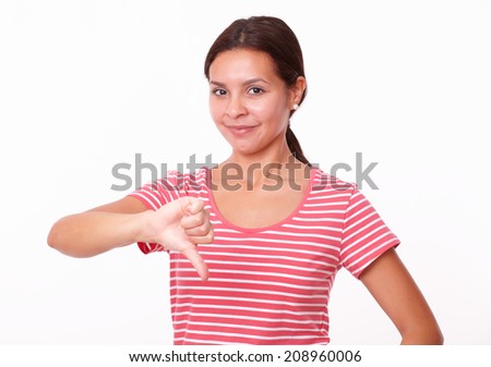Portrait of unhappy young lady on red t-shirt with thumb down looking at you on isolated studio