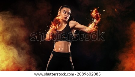 Woman boxer on black background in the fire. Boxing and fitness concept. Royalty-Free Stock Photo #2089602085