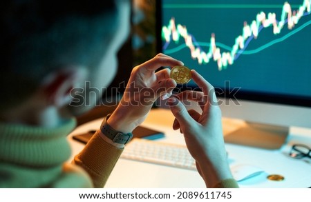 The man checks and controls the financial database on international exchanges holding gold bitcoins. Crypto trader investor analyst looks at laptop screen, analyzes financial chart data Royalty-Free Stock Photo #2089611745