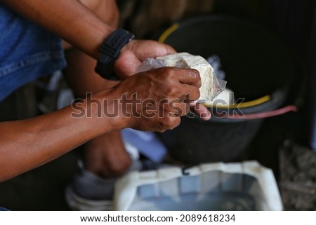 jakarta indonesia on december 12,2021: the hands of the tofu traders are putting the tofu into the plastic. selective focus. Defocused.