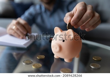 Personal savings, planning budget and money for future, frugal person concept. Close up male hand putting eur coins into piggy bank. Thrifty man add cash in moneybox thinks about tomorrow, makes stash