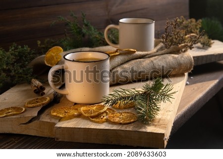 a cup of hot tea on a wooden table against a background of greens and pine needles Royalty-Free Stock Photo #2089633603