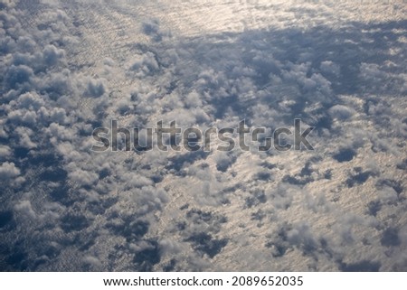 Aerial evening sky and clouds view above ocean from airplane porthole. Flight to Iceland over the North Atlantic