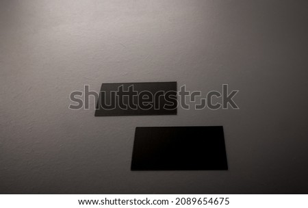 two Black mock up business card for branding on grey rustic background .