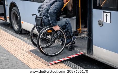 Person with a physical disability enters public transport with an accessible ramp. Royalty-Free Stock Photo #2089655170