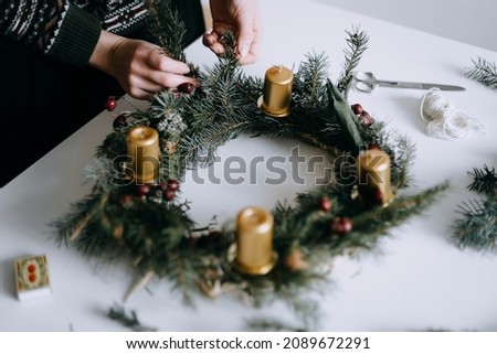 Celebrating Christmas time with homemade advent wreath with candles. Royalty-Free Stock Photo #2089672291