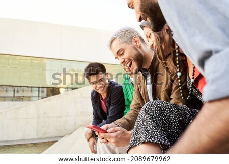 Group of happy friends using phones.