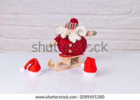 Toy Santa Claus on a New Year's sleigh on a light background. Christmas background