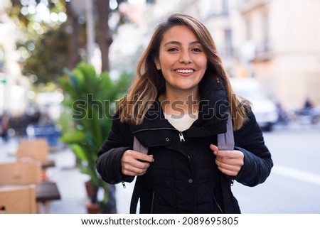 Positive latin american girl walking along city street Royalty-Free Stock Photo #2089695805