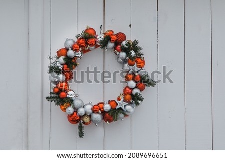 Holiday wreath decorated with red and silver balls.