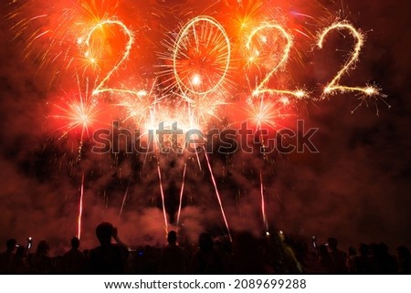 People celebrate new year`s eve, text 2022 of sparklers 2022 and Sparkle firework in the sky.