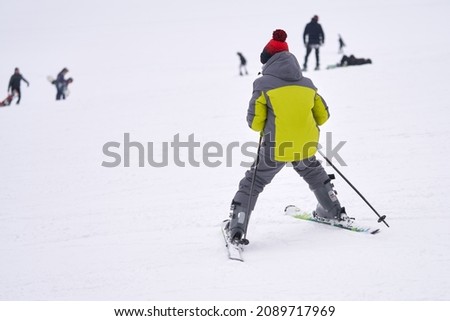A teenage boy carefully skis down a snow-covered mountainside. He is a novice skier. Copy  space.                                Royalty-Free Stock Photo #2089717969