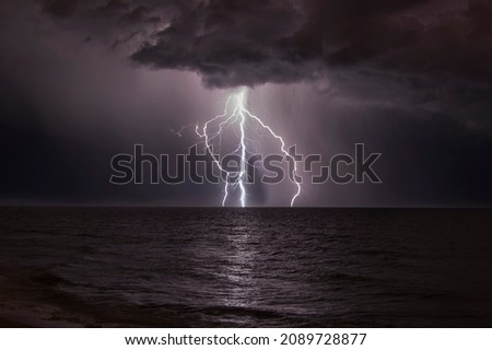 Dramatic lightening, thunder bolt in night sky over sea Royalty-Free Stock Photo #2089728877